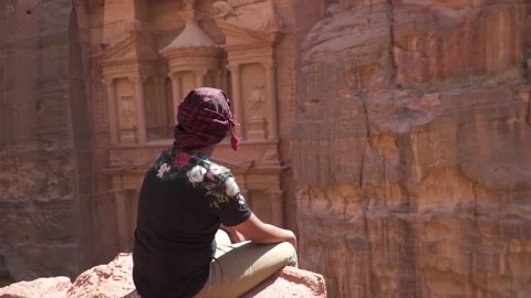 Man sitting and look into The Treasury ancient ruin building in Petra Jordan. Stock Footage 167811802