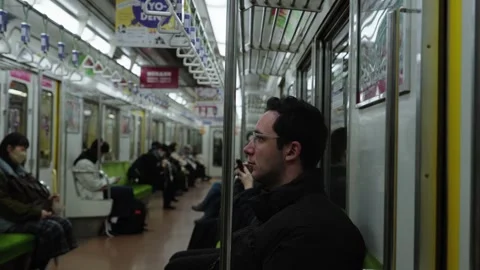 Man Sitting and Looking Out Window Inside Japanese Subway Train Car Stock Footage 336386867