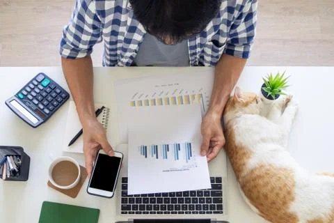 Man sitting and working on the table at home to comply with company policy. W Stock-Fotos