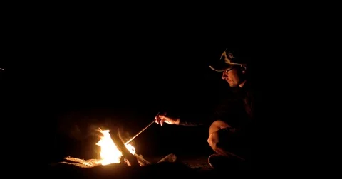 Man Sitting Around the Campfire at Night Stock Footage 71793282