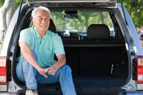 Man sitting in back of van smiling Stock Photos