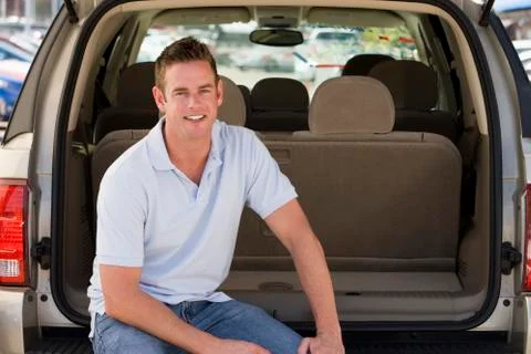 Man sitting in back of van smiling Stock Photos