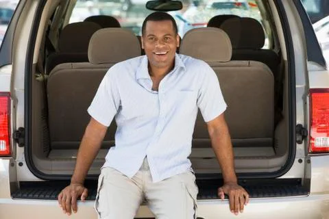 Man sitting in back of van smiling Stock Photos