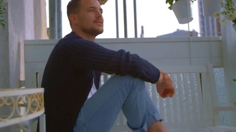 Man sitting on balcony Stock Footage 103142462