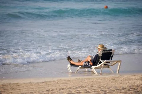 Man sitting at the beach Stock Photos