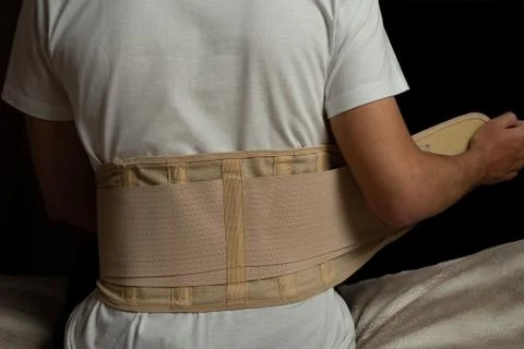 Man sitting at a bed and has pain in the back. Spine support for muscle back Stock Photos
