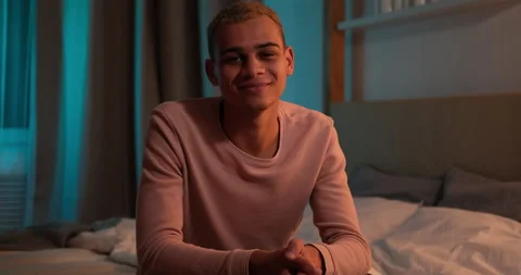 Man sitting on bed and smiling at night Video stock 145292974