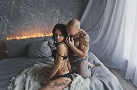 The man sitting on the bed stroking long thick hair girl 263. Stock Photos
