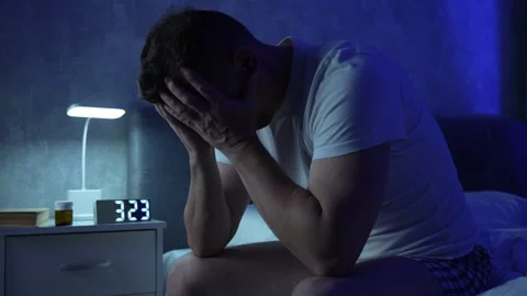 Man sitting on bed suffering from insomnia. Depressed and tired man in bed .. Stock Footage 289561887