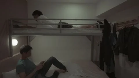 A man is sitting on a bed with a video game controller in his hand Video stock 314666803