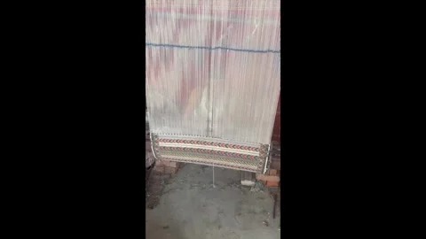 Man sitting behind machine, threading an Indian rug Stock Footage 290422408