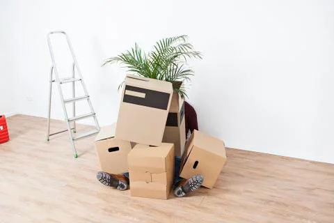 Man sitting behind stack of cardboard boxes Stock Photos
