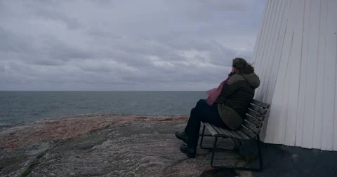 Man sitting on bench by a lighthouse. Stock-Footage 106120908
