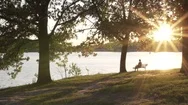 Man Sitting On Bench Near Lake At Sunset/Sunrise (Steadicam) (Ungraded) 2 Stock Footage