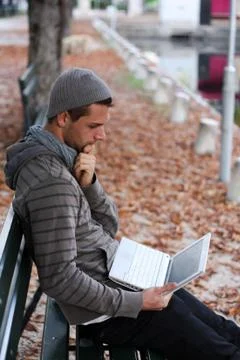 Man sitting on a bench with netbook Foto stock