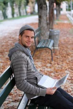 Man sitting on a bench with netbook Stock Photos