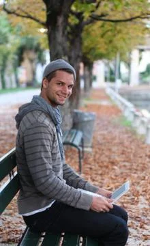Man sitting on a bench with netbook Stock Photos