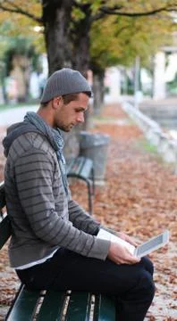 Man sitting on a bench with netbook Stock Photos