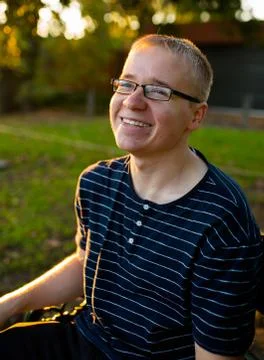 Man sitting on bench in park smiling - portrait Stock Photos
