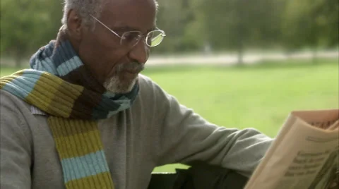 A man sitting on a bench reading a newspaper, Sweden. Stock Footage 51852285