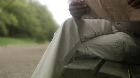 A man sitting on a bench reading a newspaper, Sweden. Stock Footage 51852294