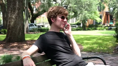 Man Sitting on Bench Talking on Phone in Slow Motion Stock Footage 40292273