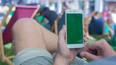 Man sitting on the bench uses SmartPhone with green screen 5 Stock Footage 116405329