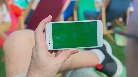 Man sitting on the bench uses SmartPhone with green screen 6 Stock Footage 116405520