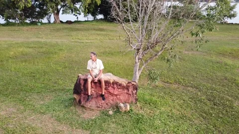 Man Sitting on a Big Rock at Parque das Garcas Video stock 169259998