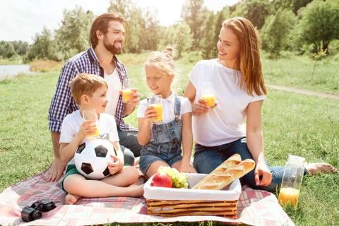 Man is sitting on blanket and looking at his wife. She is looking at him. Kids Stock Photos