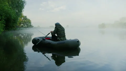 A man is sitting in a boat and preparing spinning for fishing Stock Footage 220208048