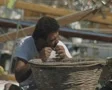 Man sitting on boat weaving net SD Footage
