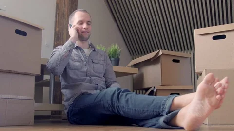 Man sitting by boxes talking on cell phone Stock-Footage 72230651