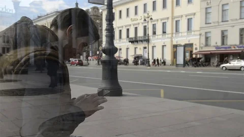 Man sitting at the bus stop and using the phone 動画素材 75417727