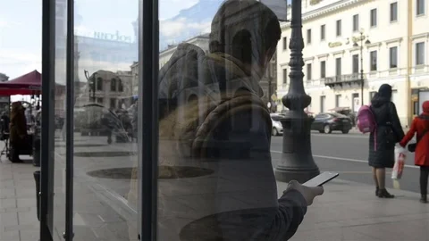 Man sitting at the bus stop and using the phone 動画素材 75418092