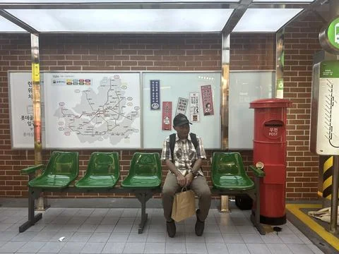 Man sitting at the bus stop Stock Photos