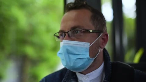 Man sitting on the bus wearing face mask during coronavirus pandemic. Video stock 156190563
