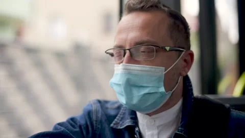 Man sitting on the bus wearing face mask during coronavirus pandemic. Stock Footage 156190701