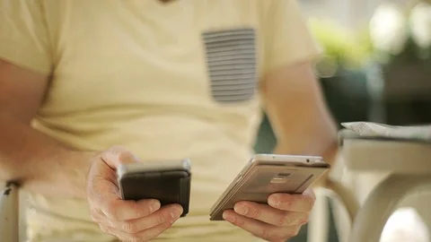 Man sitting in the cafe and using two smartphones Stock-Footage 76990577