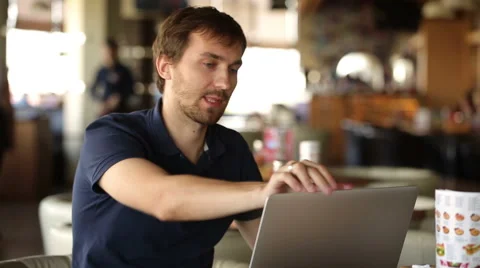 A man sitting in a cafe and working at a laptop Stock Footage 56564654