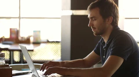 A man sitting in a cafe and working at a laptop Stock Footage 56565953