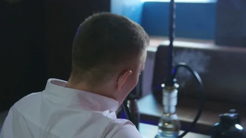 A Man is Sitting in a Cafe in Front of a Hookah Stock Footage 75259250