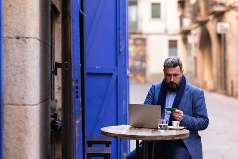 Man sitting in cafe outside using his laptop and credit card Stock Photos