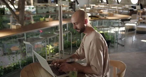Man sitting at cafe table and working on laptop Stock Footage 159083286