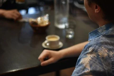 Man sitting at cafe table with cup of coffee Stock Photos