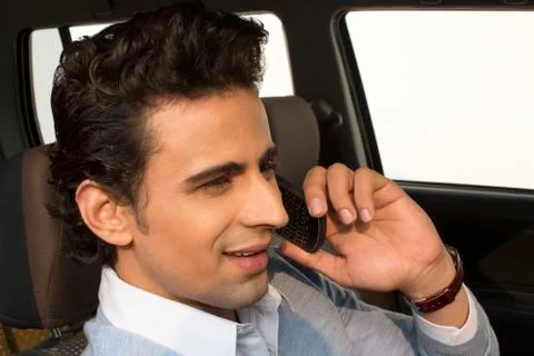 Man sitting in a car and talking on a mobile phone Stock Photos