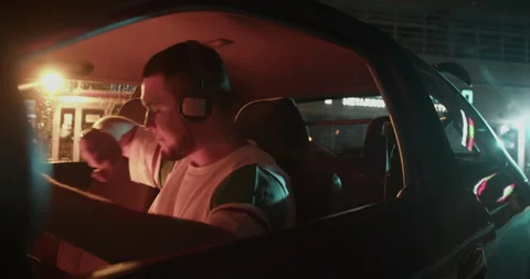 Man sitting in car and training dance moves with music on headphones Stock Footage 244525993
