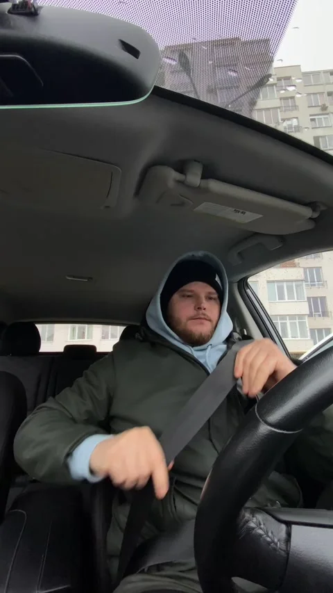 Man sitting in car getting cold fasten the safety belt Stock Footage 246304993