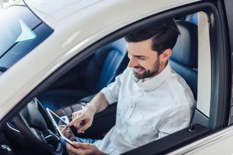 Man sitting in the car using digital tablet Stock Photos