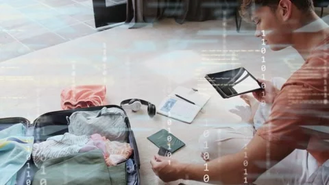 Man sitting on carpet, using tablet overlay and inspecting passport, organizing Stock Footage 333552774